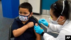 Six-year-old Eric Aviles receives the Pfizer COVID-19 vaccine from pharmacist Sylvia Uong at a pediatric vaccine clinic for children ages 5 to 11 set up at Willard Intermediate School in Santa Ana, Calif., Nov. 9, 2021.