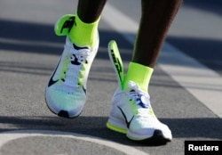 The insoles of Kenya's Eliud Kipchoge's running shoes are seen slipping up to his ankles, after he crosses the finish line to win the men's 42nd Berlin marathon, in Berlin, Germany, Sept. 27, 2015.