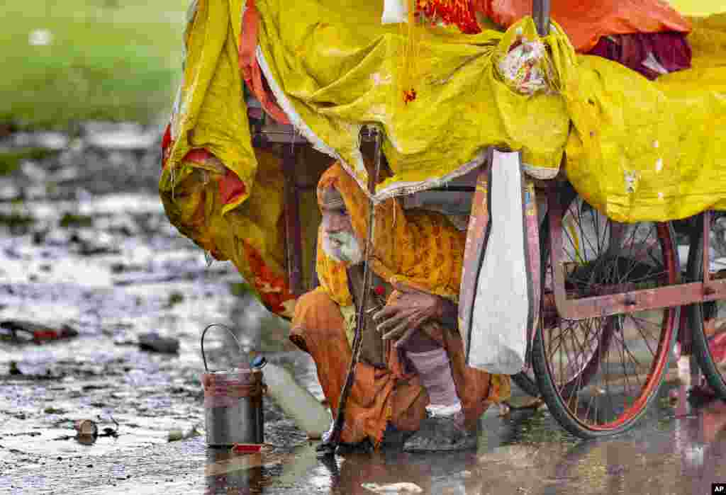 یک راهب هندو در پرایاگراج در شمال هند از باران شدید زیر گاری خود پناه گرفته است. باران شدید در یک هفته گذشته در هند موجب سیلاب و آبگرفتگی در مناطق مختلف و مرگ چندین نفر شد.