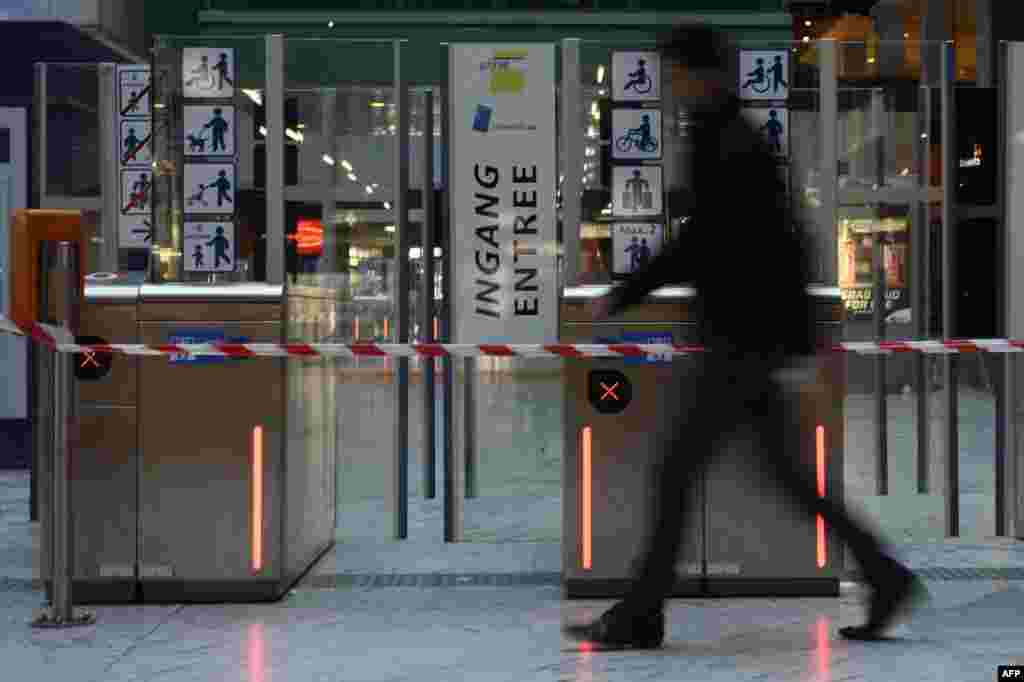 A man walks past the entrance of a closed subway station in Brussels.