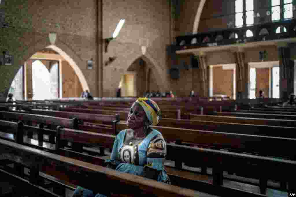 یک زن در کلیسایی در پایتخت کنگو. در انتخابات کنگو قرار است جانشین جوزف کابیلا انتخاب شود که ۱۵ سالدر قدرت بود. &laquo;رمـضانی شاداری&raquo; نامزد مورد حمایت حزب حاکم در لیست تحریم&zwnj;های اتحادیه اروپا برای خشونت علیه مخالفان قرار دارد.