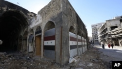 시리아 반군이 홈스 시에서 퇴각하고 있는 가운데, 내전으로 파괴된 상점이 8일 새 문을 단 모습이다. 