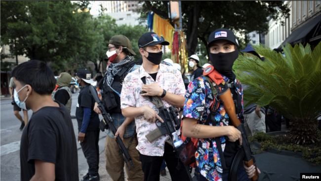 Një anëtar i Texas Guerrillas, i cili përdor pseudonimin "Apex"(i treti nga e djathta), dhe të tjerë duke mbajtur armë gjatë një proteste Black Lives Matter në Teksas (1 gusht 2020)