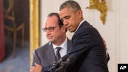 ປະທານາທິບໍດີ ສະຫະລັດ ທ່ານ Barack Obama cແລະ ປະທານາທິບໍດີ ຝຣັ່ງ ທ່ານ Francois Hollande ໂອບກອດກັນ ໃນລະຫວ່າງກອງປະຊຸມຖະແຫລງຂ່າວຮ່ວມ ໃນຫ້ອງກ້ຳຕາເວັນອອກຂອງທຳນຽບຂາວທີ່ວໍຊິງຕັນ, ວັນທີ 24 ພະຈິກ 2015.