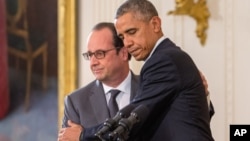 President Barack Obama and French President Francois Hollande embrace during a joint news conference in the East Room of the White House in Washington, Nov. 24, 2015.