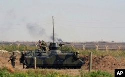 FILE - This Oct. 5, 2012, photo, Turkish military take up positions on the Turkish side of the Syrian border