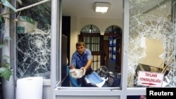 A man removes stones at the Thai honorary consulate in Istanbul, Turkey, July 9, 2015. Thailand confirmed on Thursday it had forcibly returned nearly 100 Uighur migrants to China. (REUTERS/Osman Orsal)