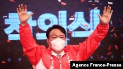 FILE - Former prosecutor general Yoon Seok-yeol from South Korea's main opposition People Power Party waves after being chosen as the party's candidate in next year's presidential election in Seoul on Nove. 5, 2021.