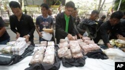 FILE - Thai policemen display intercepted drugs - 226 kilograms (498 pounds) of crystal meth and 8 kilograms (18 pounds) of heroin - during press a conference in Bangkok, Thailand, March 24, 2016. Thai police arrested 15 Malaysians as part of the heist.