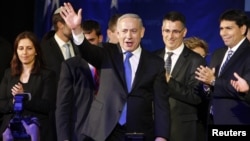 Israel's Prime Minister Benjamin Netanyahu waves to supporters as he stands with his party members at the Likud-Yisrael Beitenu headquarters in Tel Aviv January 23, 2013.