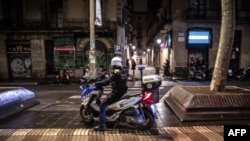 Un policía de la guardia urbana de Barcelona informa a los transeúntes sobre la introducción de un toque de queda en La Rambla, en Barcelona, en la noche del 23 de diciembre al 24 de diciembre de 2021.
