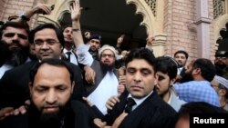 Hafiz Saeed (C) reacts to supporters as he walks out of court after a Pakistani court ordered his release from house arrest in Lahore, Pakistan, Nov. 22, 2017. 