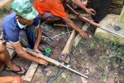 FILE - Members of the People's Defense Force (PDF) make handmade guns to be used in their fight against security forces, near Demoso, Kayah state, Myanmar, as the country remains in turmoil after the February military coup.