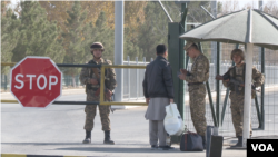 Uzbek border security officers inspecting an Afghan citizen at Termez-Hairatan crossing, Uzbekistan, Nov. 3, 2021 (VOA)