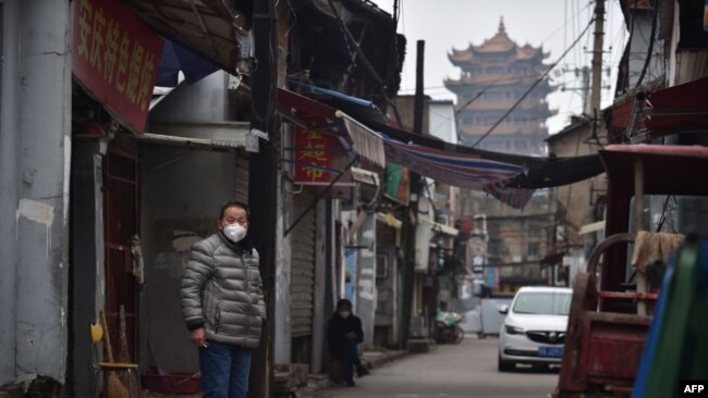 武汉黄鹤楼旁一条巷子里站着一个带着口罩的男人 （2020年2月26日）