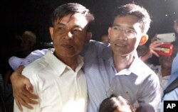 Two former Radio Free Asia reporters Uon Chhin, left, and Yeang Socheamet, right, hold together after they walk outside the main prison of Prey Sar at the outskirt of Phnom Penh, Cambodia, Aug. 21, 2018.