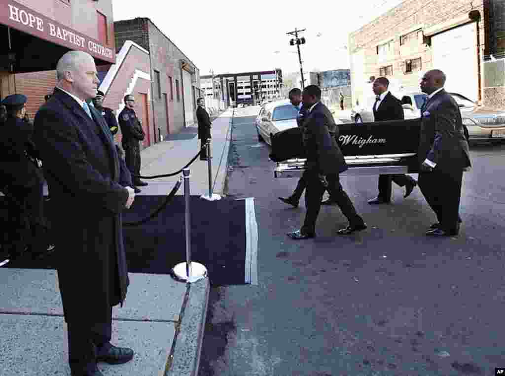 A coffin holding the remains of singer Whitney Houston is carried into the New Hope Baptist Church before funeral services for the singer in Newark, New Jersey, February 18, 2012. (AP)