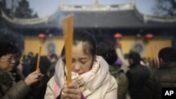 Seorang perempuan berdoa di kuil Longhua pada hari pertama Tahun Baru China di Shanghai, Februari 2013. (Foto: Dok)