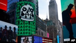 FILE - An NFT, or non-fungible token, is displayed on a billboard in Times Square, New York, on Nov. 4, 2021. Collins Dictionary has chosen NFT as its "Word of the Year" after surging interest in the digital tokens brought it into the mainstream.