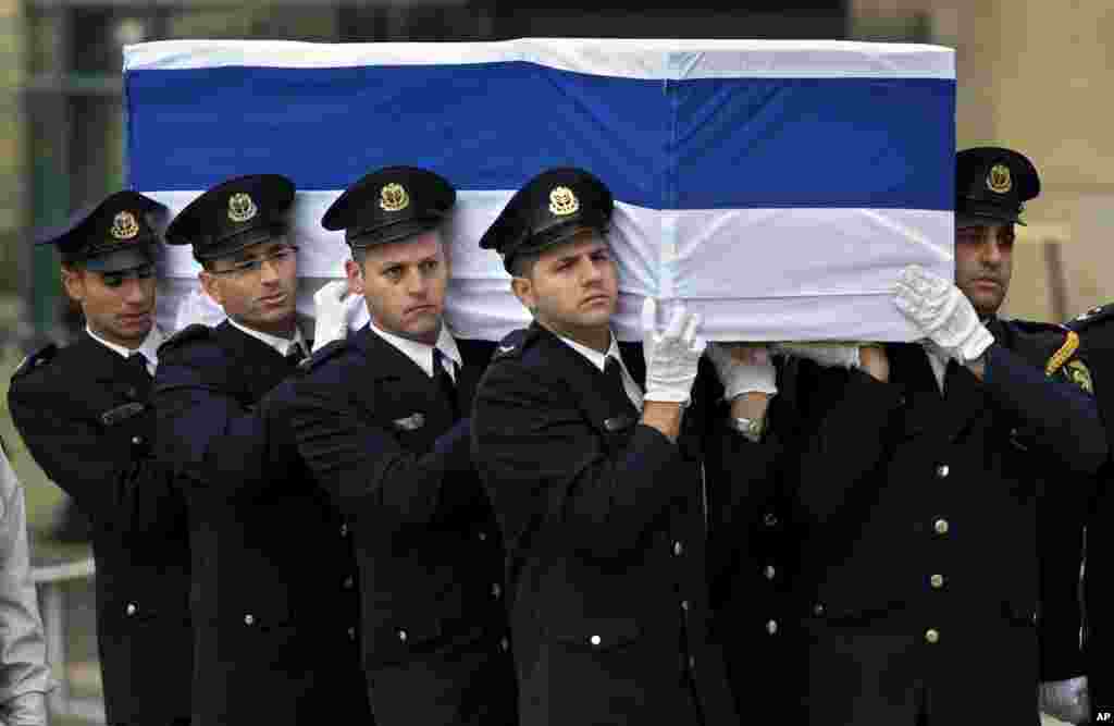 Petugas keamanan di Knesset membawa peti jenazah mantan perdana menteri Israel Ariel Sharon di Plaza Knesset, Yerusalem (12/1). (AP/Bernat Armangue)