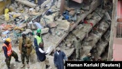 Petugas penyelamat mencari penghuni yang ditakutkan terperangkap dalam puing-puing bangunan yang ambruk akibat hujan deras di Nairobi, Kenya (30/4). (Reuters/Harman Kariuki)