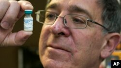 Pediatrician Charles Goodman holds a dose of the measles-mumps-rubella vaccine, or MMR vaccine at his practice in Northridge, California, Jan. 29, 2015.