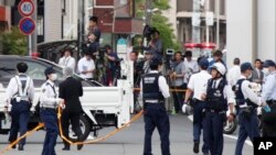 Police officers work at the scene where a man wielding a knife attacked commuters in Kawasaki, near Tokyo Tuesday, May 28, 2019