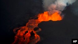 ARCHIVO - En esta foto del 10 de junio de 2018, la lava del volcán Kilauea continúa erupcionando desde una fisura y forma un río de lava que fluye hacia Kapoho en Pahoa, Hawaii. (AP Photo / L.E. Baskow, archivo). El huracán Héctor con categoría 4 se dirige hacia Hawai informó el Centro Nacional de Huracanes de EE.UU., el domingo.