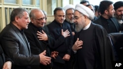 Iranian President Hassan Rouhani, right, greets Mohsen Hashemi, left, son of former President Akbar Hashemi Rafsanjani, who died on Sunday after suffering a heart attack, in a mourning ceremony at the Jamaran mosque in northern Tehran, Jan. 9, 2017. 