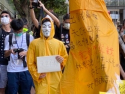 化名V的年青人穿上梁凌杰死前的黄色雨衣，象征与梁凌杰同样为民主自由站出来抗争。 (美国之音/汤惠芸)