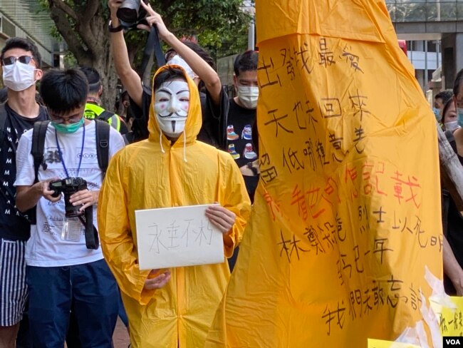 化名V的年青人穿上梁凌杰死前的黄色雨衣，象征与梁凌杰同样为民主自由站出来抗争。 (美国之音/汤惠芸)