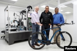 (L-R) Arevo Labs CEO Jim Miller, CTO Wiener Mondesir, and Chairman and Co-Founder Hemant Bheda stand for a photo with the company's 3-D-printed carbon fiber commuter bike in Santa Clara, California, May 10, 2018.