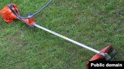 A grass cutter sits on a lawn.