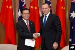 2015年6月17日澳大利亚堪培拉议会大厦： 澳大利亚总理艾伯特(右)与中国商务部长高虎城握手