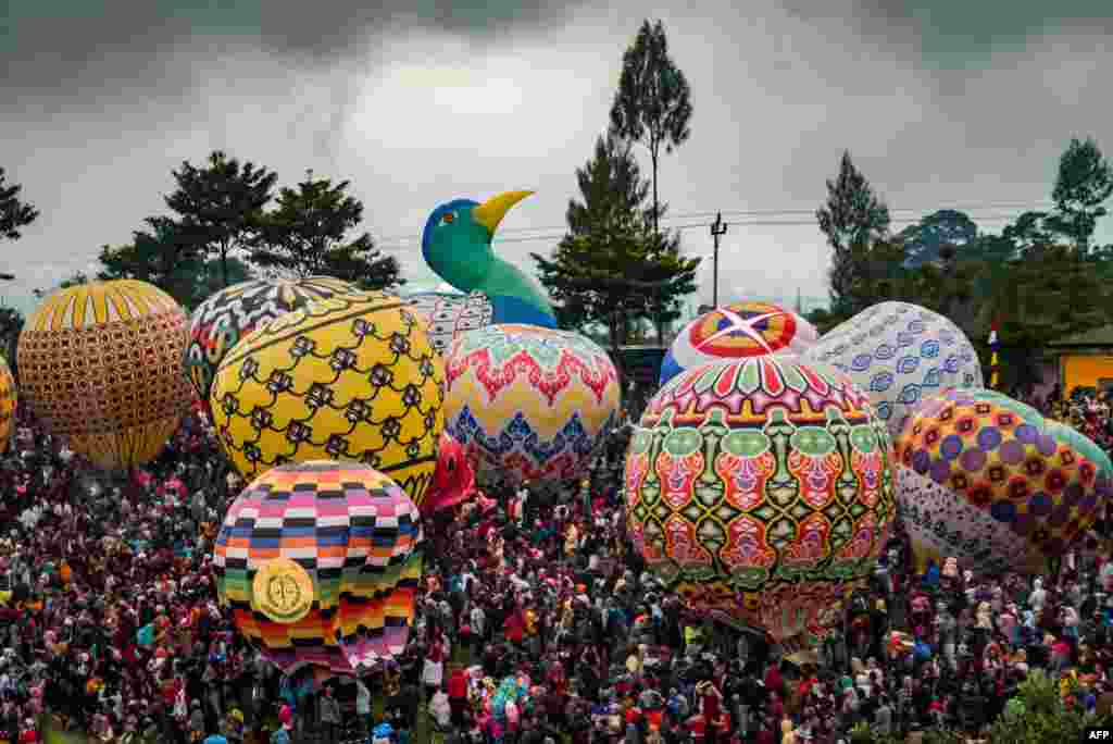 Indonesians prepare to release hundreds of giant balloons at Pagerejo field in Wonosobo, Central Java province during the 2019 Java Traditional Balloon Festival to educate people about flying safety, June 15, 2019.
