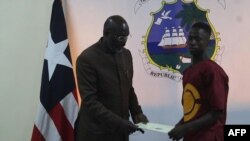 Emmanuel Tuloe, l'adolescent libérien qui avait ramassé 50.000 dollars, avec le président George Weah, le 22 octobre 2021.