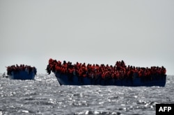 FILE - Migrants wait to be rescued as they drift in the Mediterranean Sea some 20 nautical miles north off the coast of Libya, Oct. 3, 2016.
