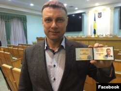 Member of parliament Vitaliy Kupriy holds up his registration as a candidate in Ukraine's upcoming presidential elections, in an undated photo from his Facebook page.