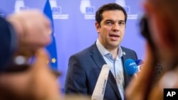 Greek Prime Minister Alexis Tsipras speaks with the media after a meeting of eurozone heads of state at the EU Council building in Brussels, July 13, 2015. 