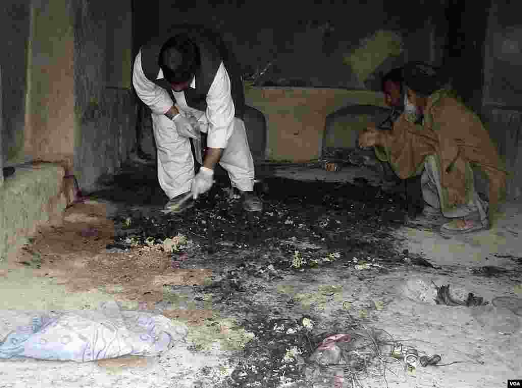 Afghan men investigate at the site of the shooting incident in Panjwai. (Reuters)