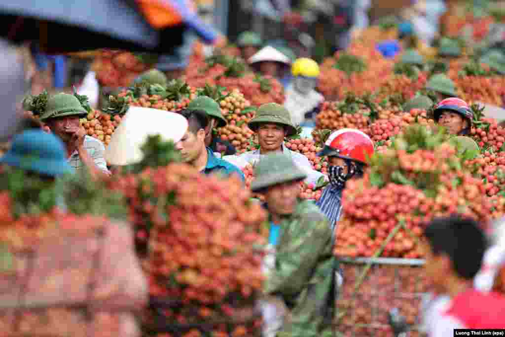 People carry lychees to sell, on a street in Luc Ngan, Bac Giang province, Vietnam.