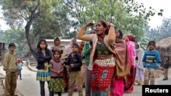 Family members mourn for their relatives, who died after consuming locally brewed liquor, outside their residence at Malihabad town in the northern Indian state of Uttar Pradesh, Jan. 13, 2015.