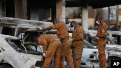 Des soldats examinent des voitures brûlées devant le Splendid Hotel à Ouagadougou, Burkina Faso, après qu'il ait été attaqué par des extrémistes liés à Al-Qaida, le 17 janvier 2016. (AP Photo/Sunday Alamba, archives)