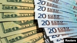 FILE - U.S. dollars and euros banknotes are seen in this illustration photo taken at a change bureau in Paris.