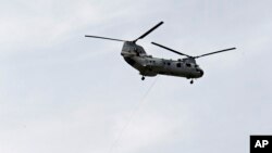 FILE - A CH-46 "Sea Knight" helicopter snatches four Marines off the runway at Burke Lakefront Airport in Cleveland.