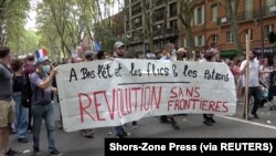 Para pengunjuk rasa membawa spanduk selama demonstrasi menentang pembatasan Perancis, termasuk izin kesehatan wajib di tengah pandemi COVID-19, di Toulouse, Perancis, 11 September 2021. (Foto: Shors-Zone Press via REUTERS)
