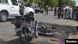 Security officers stand at the site of a suicide bombing in Ndjamena, Chad, June 15, 2015.