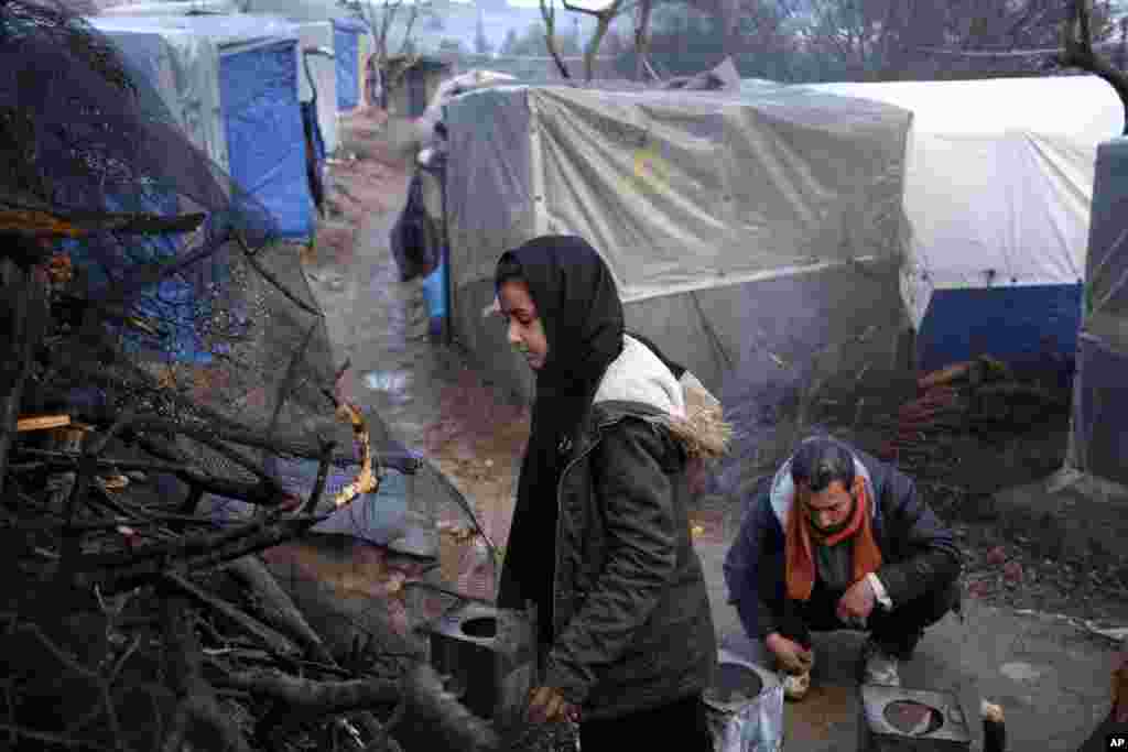 پناهندگان و مهاجران در کمپ با روشن کردن آتش خود را از سرمای پس از باران در جزیره لزبو در یونان گرم می&zwnj;کنند.