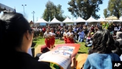 The crowd is watching a traditional dance during the Cambodian Culture Festival at MacArthur Park, Long Beach, California.