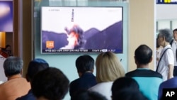 People watch a TV news program showing a file footage of North Korea's ballistic missile that the North claimed to have launched from underwater, at Seoul Railway station in Seoul, South Korea, July 9, 2016.